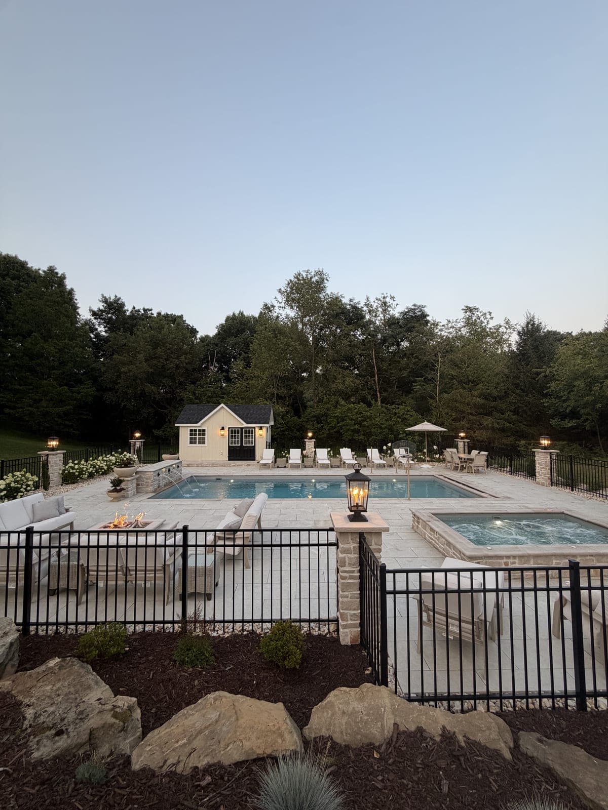 Twilight view of pool, spa, and fire pit lounge
